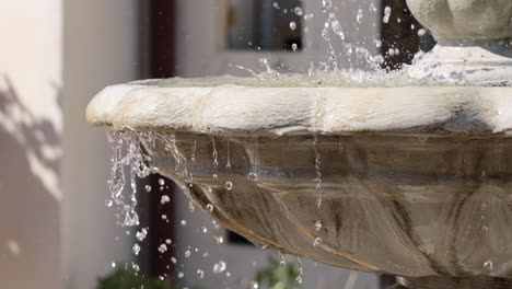 water rhythmically flows over a stone fountain edge