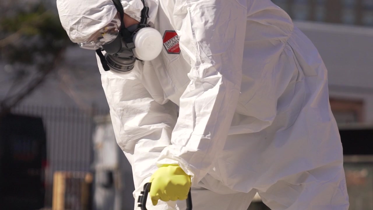 Equipo de pulverización de especialistas en desinfección de brotes de coronavirus. Limpiando el mundo con trajes de protección.