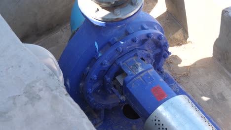 high angle shot over a blue diesel pump used for drawing water from a nearby water body to irrigate the nearby fields