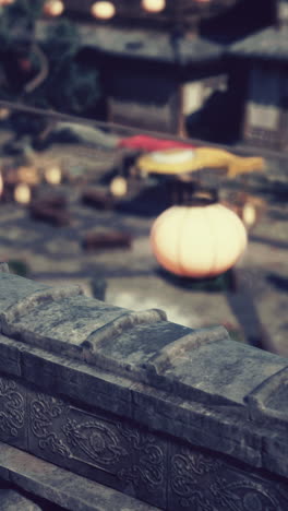 close-up of a stone roof with lanterns in the background