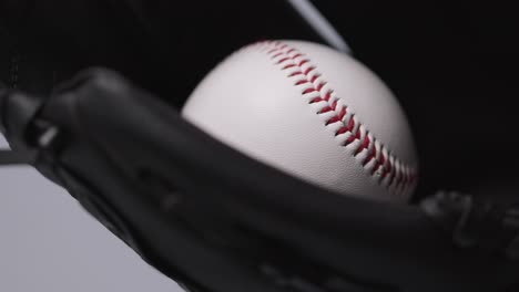 close up baseball shot with baseball ball being thrown and caught in catchers mitt