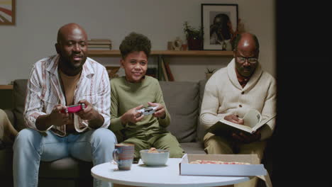 Black-men-and-boy-in-the-living-room-having-fun-at-night