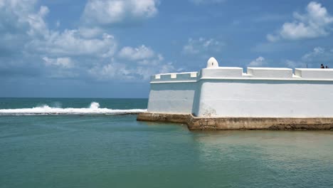 tilt up shot of the outside wall of the historic fort of the three wise men, built on the reef in the coastal capital city of natal in rio grande do norte, brazil on a warm summer day