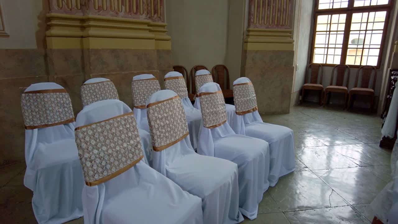 Sillas en la capilla de bodas cubiertas con fundas blancas festivas listas para la boda, Slavkov u Brna, República Checa