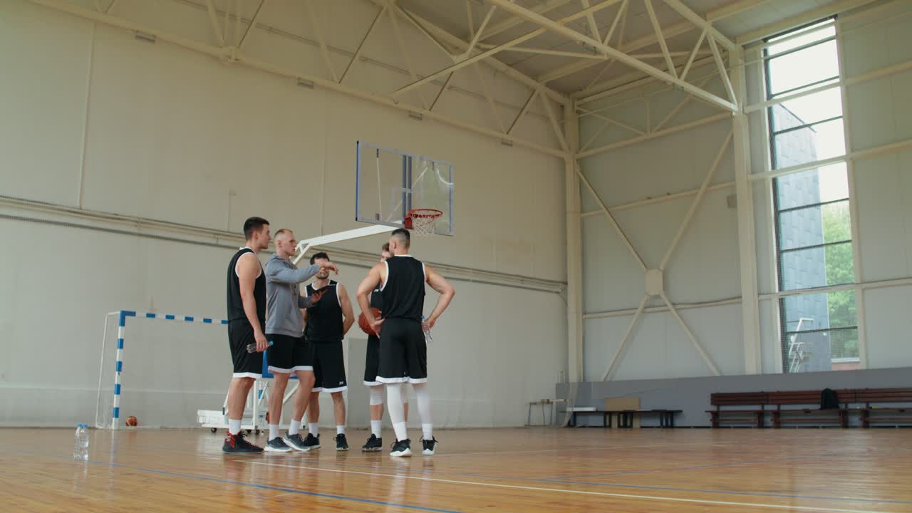 Tim basket dengan pelatih mendiskusikan strategi di lapangan