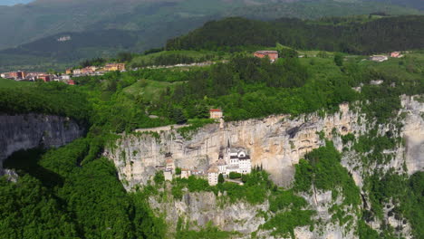 santuario della madonna della corona - cliffside sanctuary in northern italy, built into the rock face of mount baldo. aerial pullback shot