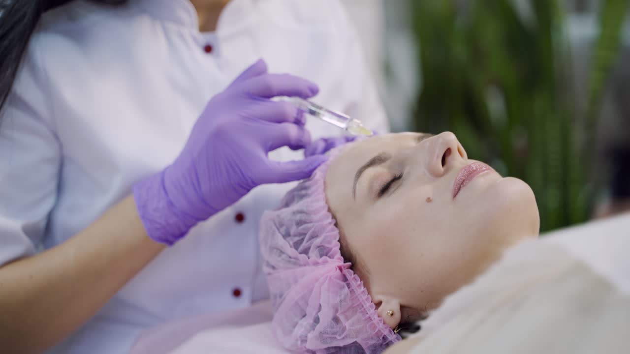Hands of cosmetologist making injection in face. Aesthetic cosmetology.