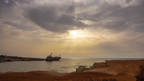 Time-lapse-of-setting-sun-above-shipwreck-off-coast-of-island