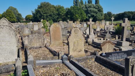 shot over old tombstones at historic crowland abbey, lincolnshire, england, on a sunny summer day, showcasing medieval gravestones and peaceful churchyard scenery