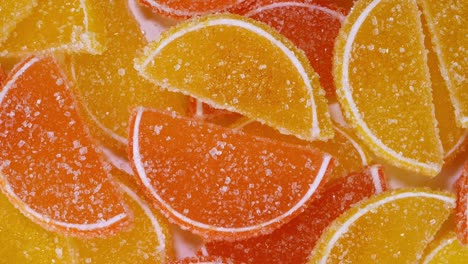 tasty orange gummy marmalade fruit jelly, sprinkled with sugar candies, rotate slowly.