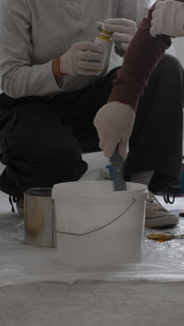 two people mixing yellow paint for home improvement project