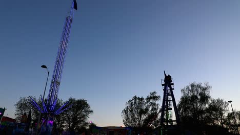 Buntes-Karussell-In-Bewegung-Mit-Sonnenuntergang-Im-Hintergrund