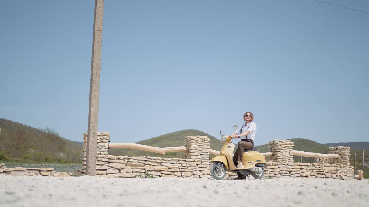 человек на старинном скутере в сельской местности