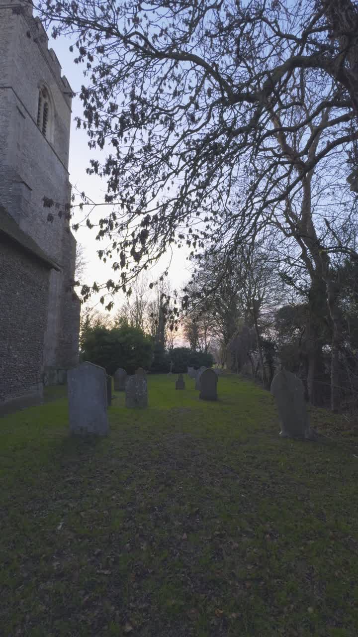 Leggera carrellata di un piccolo cimitero vicino a un'antica chiesa nella campagna inglese