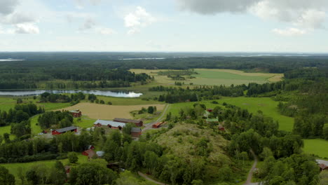 vista aérea alrededor de casas y edificios en una granja, en el campo, parcialmente soleado, día de verano, en fagervik, inkoo, finlandia - órbita, disparo con drones