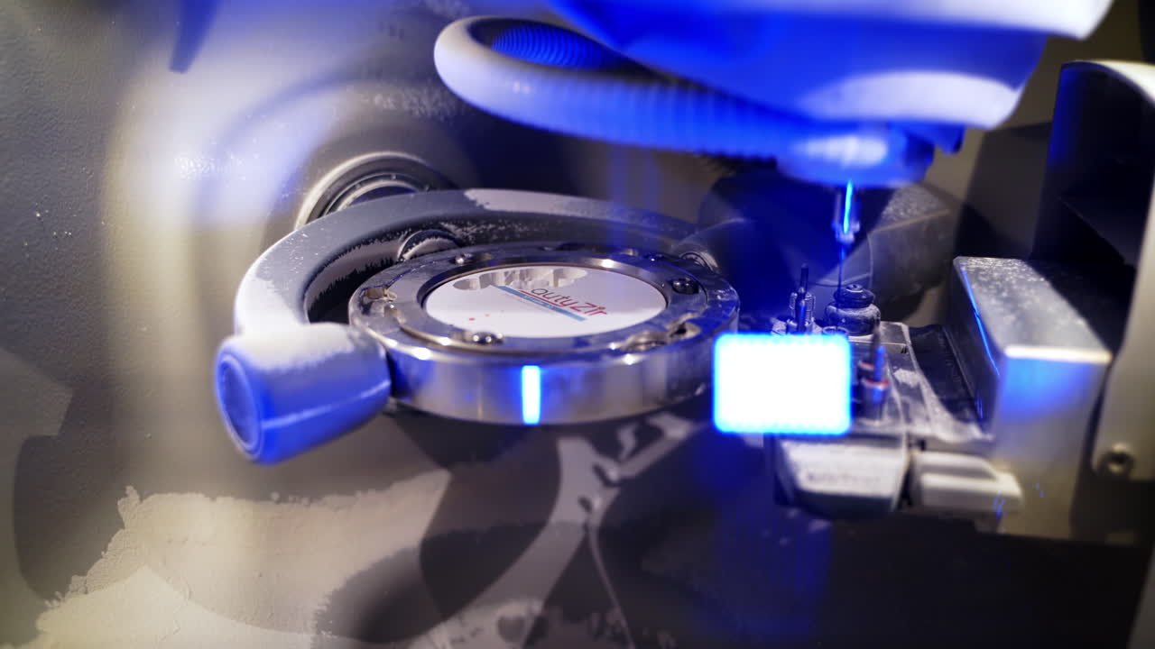 Working process of dental technician. Close up of automated milling machine producing ceramic dental implants for treatment in medical laboratory