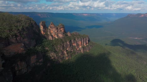 drone aerial over three sisters blue mountains katoomba sydney nsw australia echo point lookout cliff walk world heritage national park gum tree eucalyptus forest bluesky sunny day clouds forwards