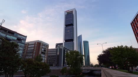 view from the bottom pointing up of skyscrapers buildings cinco torres during sunset in madrid, spain cinco torres business area and paseo de la castellana street