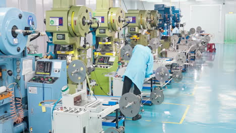 modern industrial workers or technician wearing protective gear uniform standing, conducting inspection at machine in industry factory, intelligent high-end technology dust-free production workshop