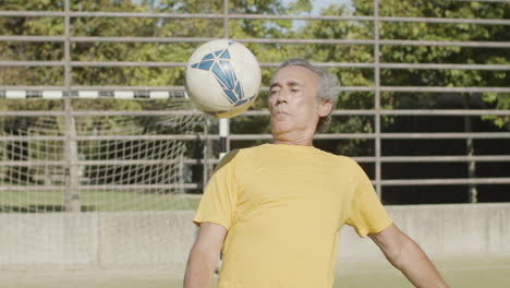 heureux homme âgé frappant et frappant le ballon à l'extérieur