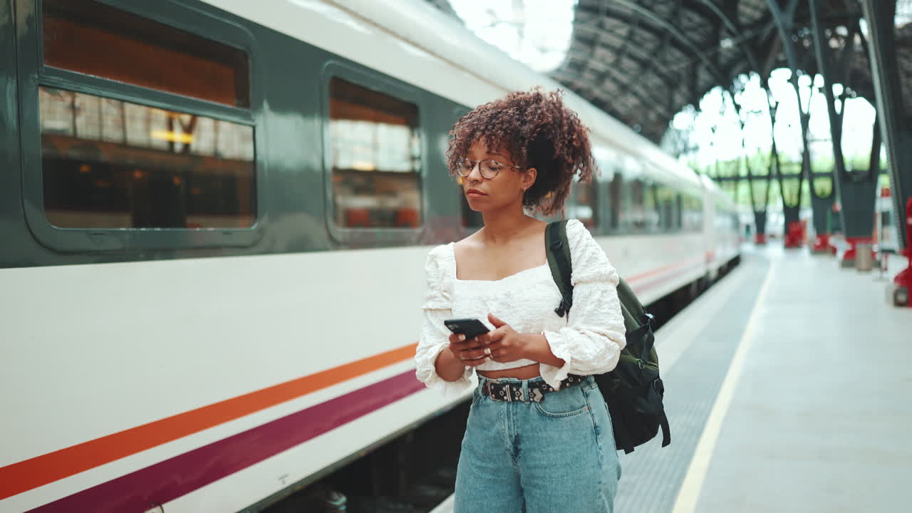 mujer que espera para el tren en la estación