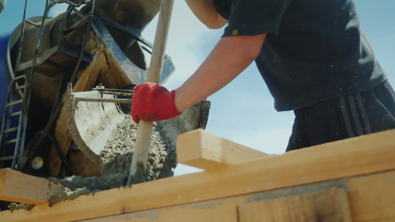 vierta hormigón de la mezcladora en el encofrado en el fondo de la construcción de nuevos edificios borrosos