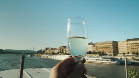 Eine-Hand-Mit-Einem-Glas-Champagner-Klirrt