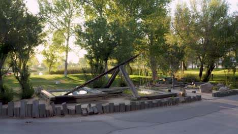 pan past wooden water fountain feature in apollo park, california, golden hour