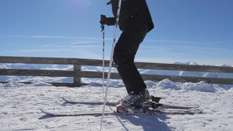 skier at the top of the mountain fastens ski boots on the ski fastening