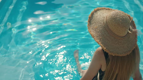 mujer relajándose en una piscina en un día soleado