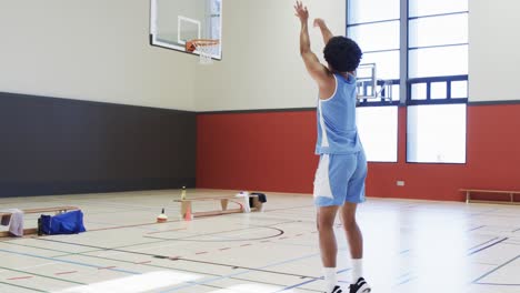 Afroamerikanischer-Männlicher-Basketballspieler-Schießt-Ball-Auf-Korb,-Training-Auf-Dem-Hallenplatz,-Zeitlupe