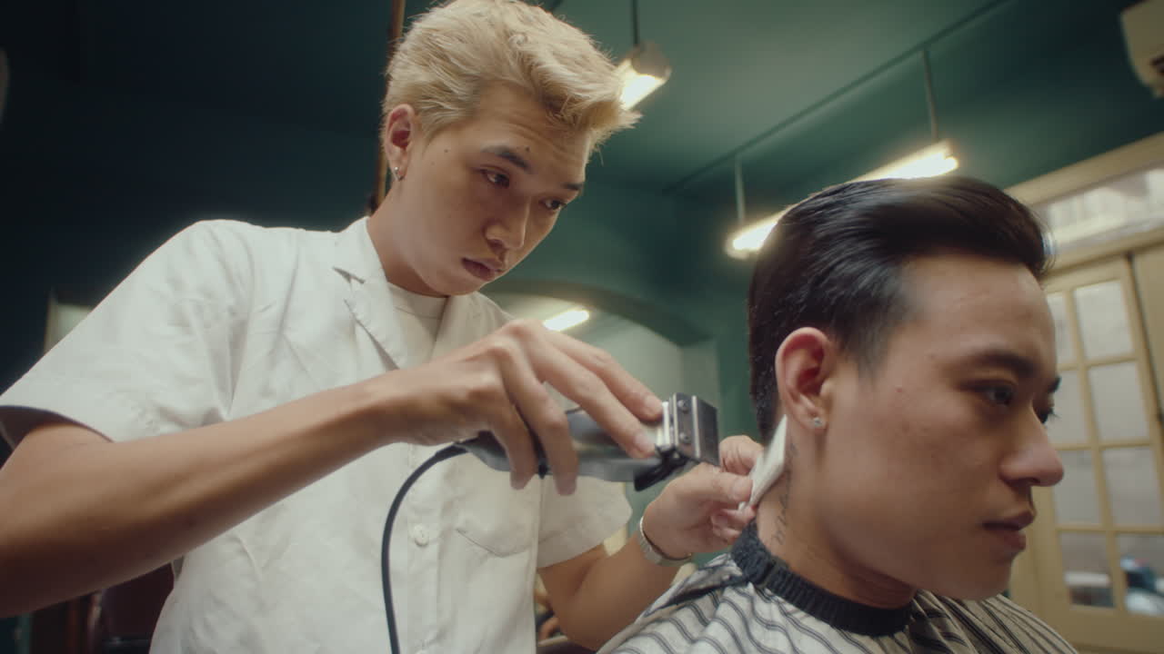 Asian Barber Giving Haircut Using Hair Clippers and Comb