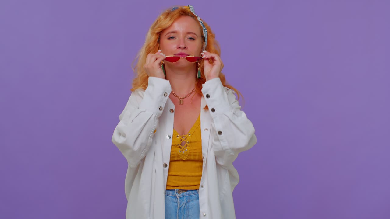 соблазнительная веселая стильная девушка в белой рубашке в солнцезащитных очках, очаровательная улыбка на фиолетовой стене