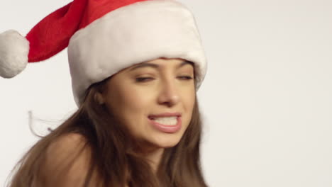 cu woman wearing santa hat sings to camera