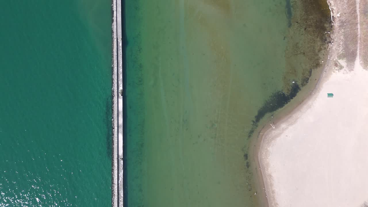 Breakwater structure, sea water and coast by Toronto, top down aerial