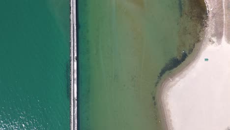 breakwater structure, sea water and coast by toronto, top down aerial