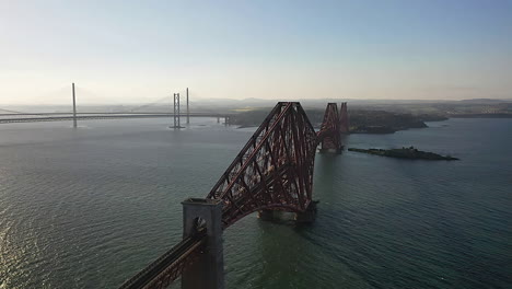 south queensferry bridges: aerial angle panning over firth of fourth to reveal the fourth bridges behind, in scotland