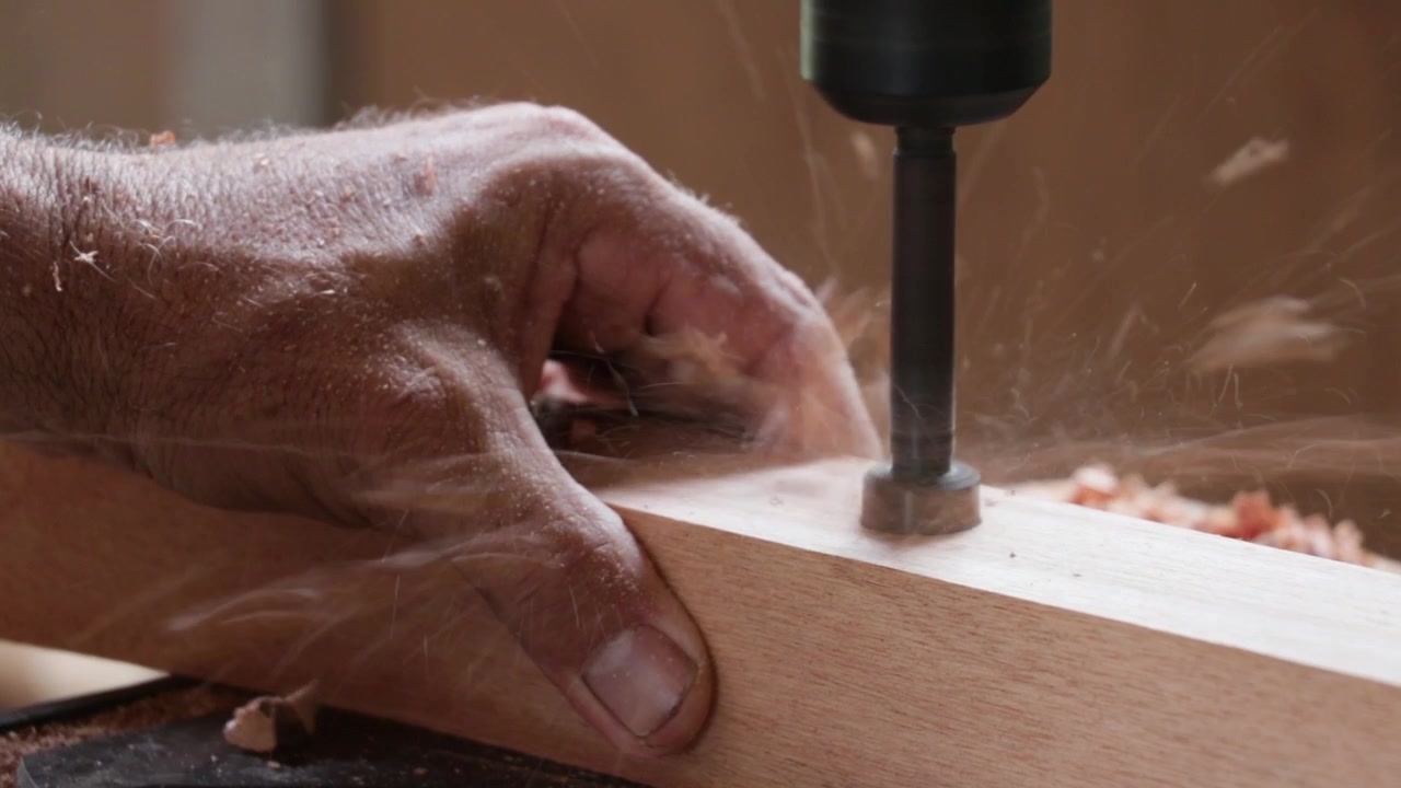 Mann fertigt einen Holzstuhl