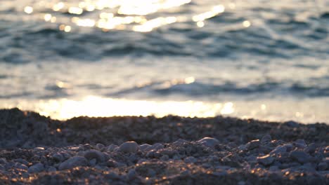 waves breaking over stone beach at sunset, tranquil coastal shoreline landscape