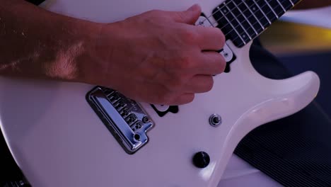 a guitarist tunes his guitar