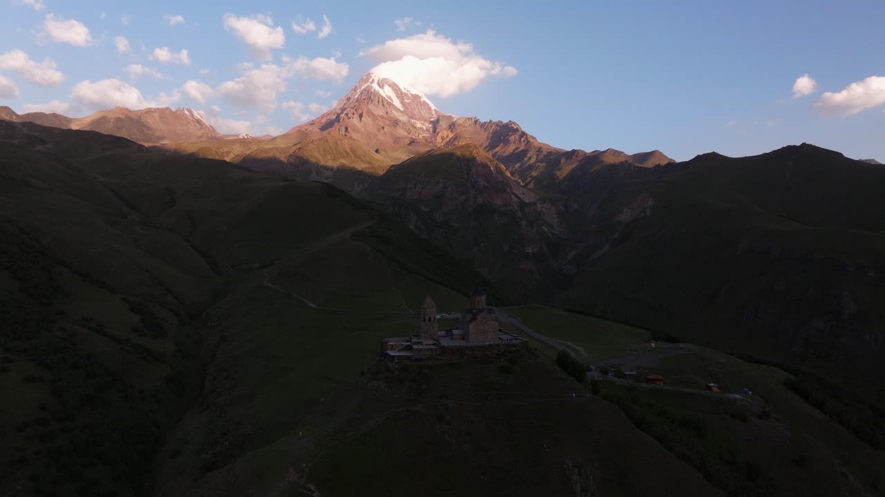 un avión no tripulado en órbita filmado por encima de la iglesia de la trinidad de gergeti, georgia