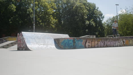 Niño-Caucásico-Haciendo-Un-Truco-En-Skatepark.