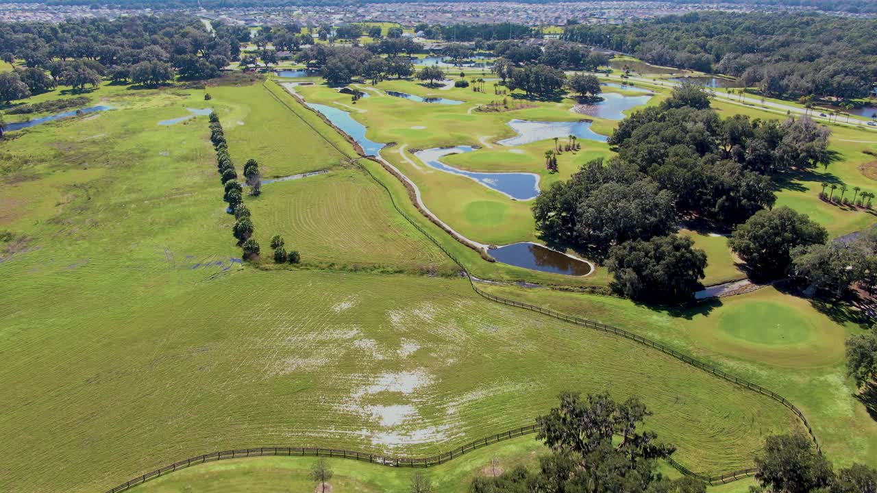 Drone flyover of the Lowlands Executive Golf Course in Wildwood, FL, showing green fairways, palm trees, and nearby Villages residences highlighting active outdoor living
