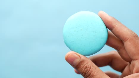 blue macaron in hand