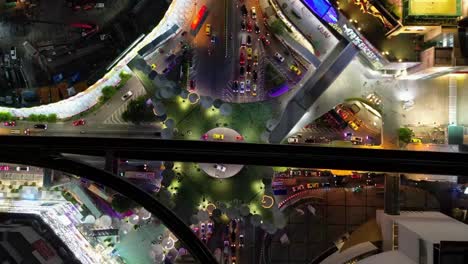drone top down of cars and traffic timelapse in vibrant cityscape of towering buildings and illuminated streets, showcasing urban energy and modern life