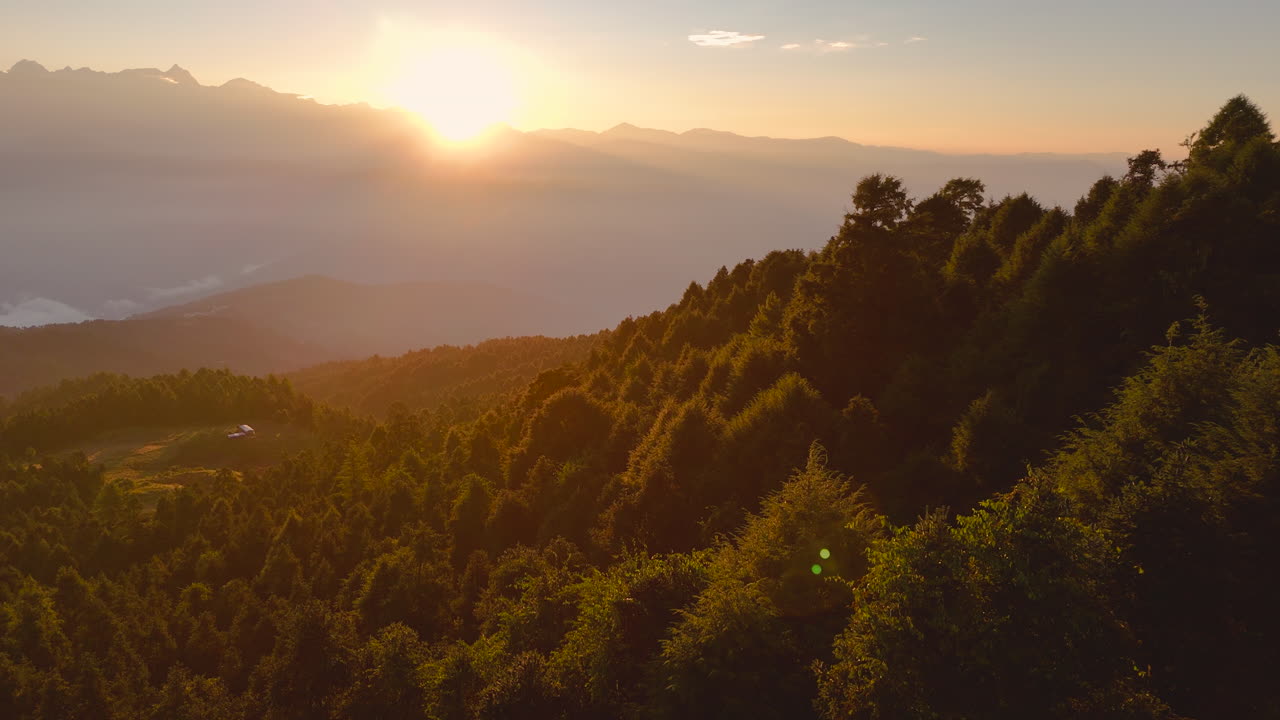 드론 촬영은 티베트 근처의 밀집한 산림인 샤이롱, 도라카, 네팔에서 해가 뜨는 것을 포착합니다. 산맥과 언덕에 반사되는 빛으로 평화롭고 모험적인 자연 탈출을 제공합니다.