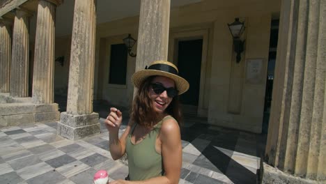 carefree woman walking on column building corridor at summer travel