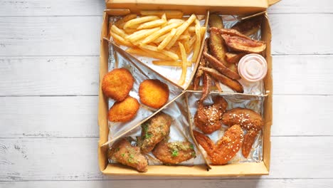 box meal with fries, wings, and potato wedges