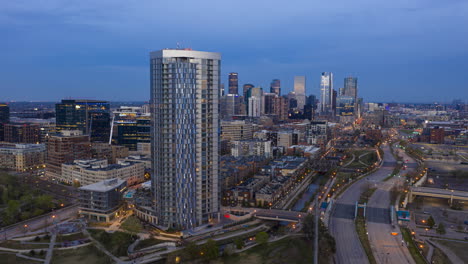 rising aerial hyperlapse of the confluence apartment complex in the evening with downtown denver, colorado in the distance