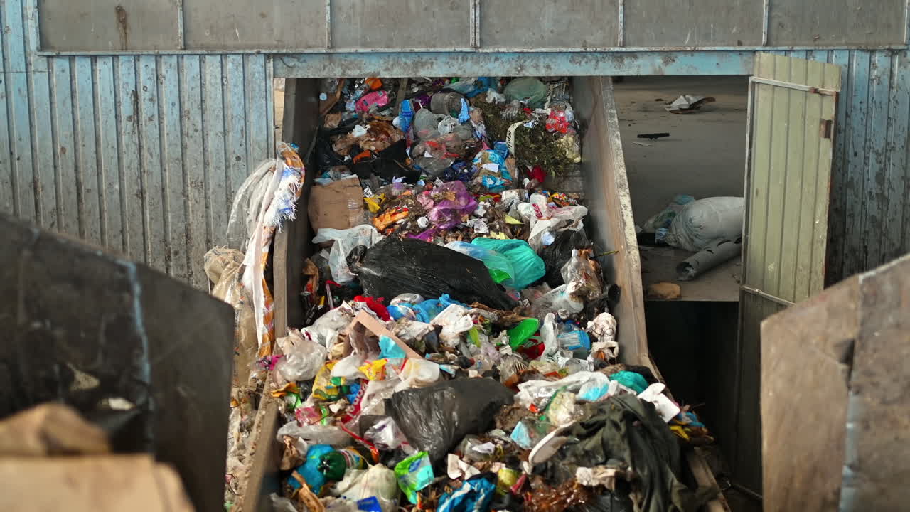 Garbage moving on a conveyor belt at waste sorting plant. Slow motion